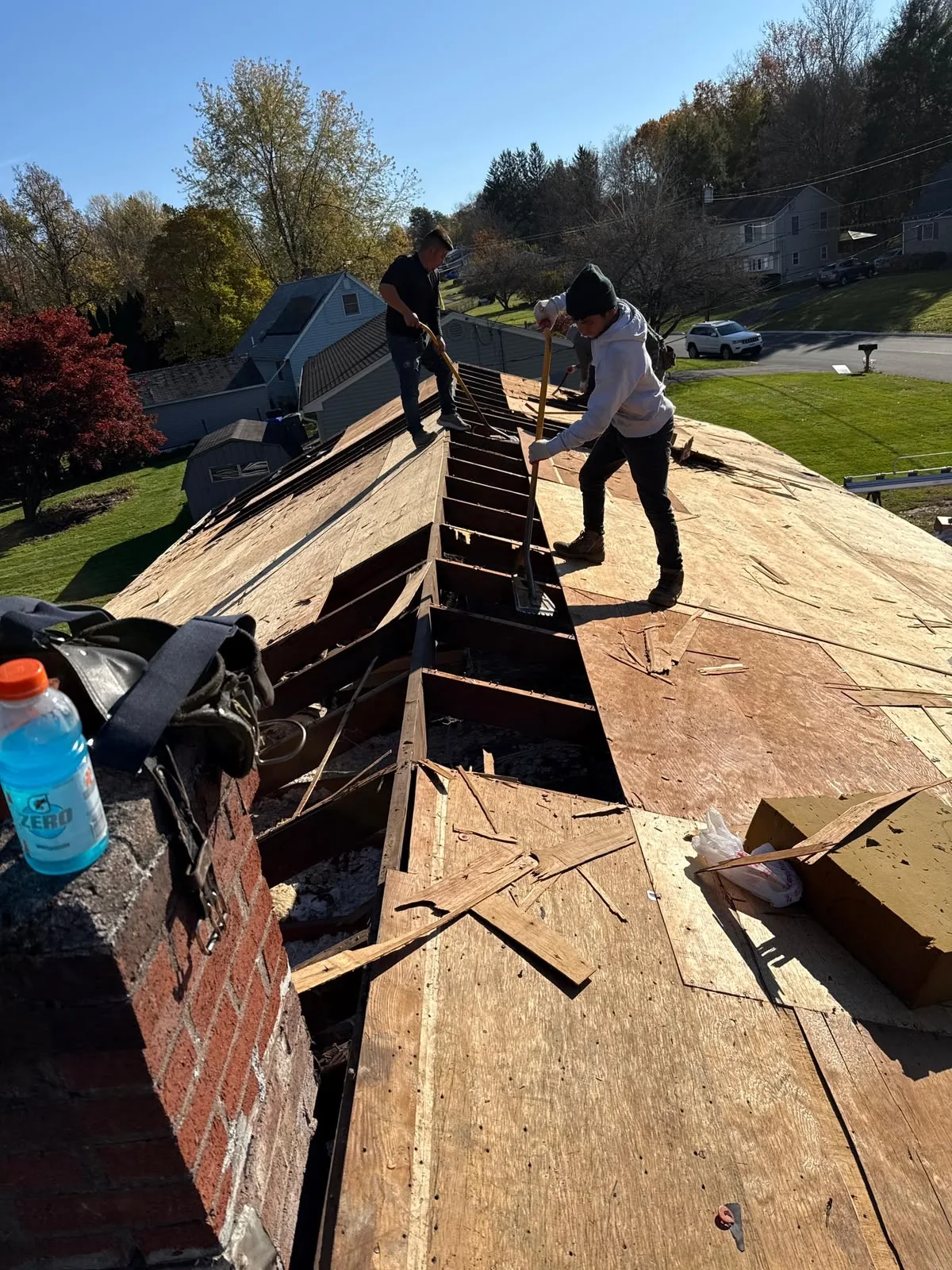 Roofing crew working on exposed roof decking